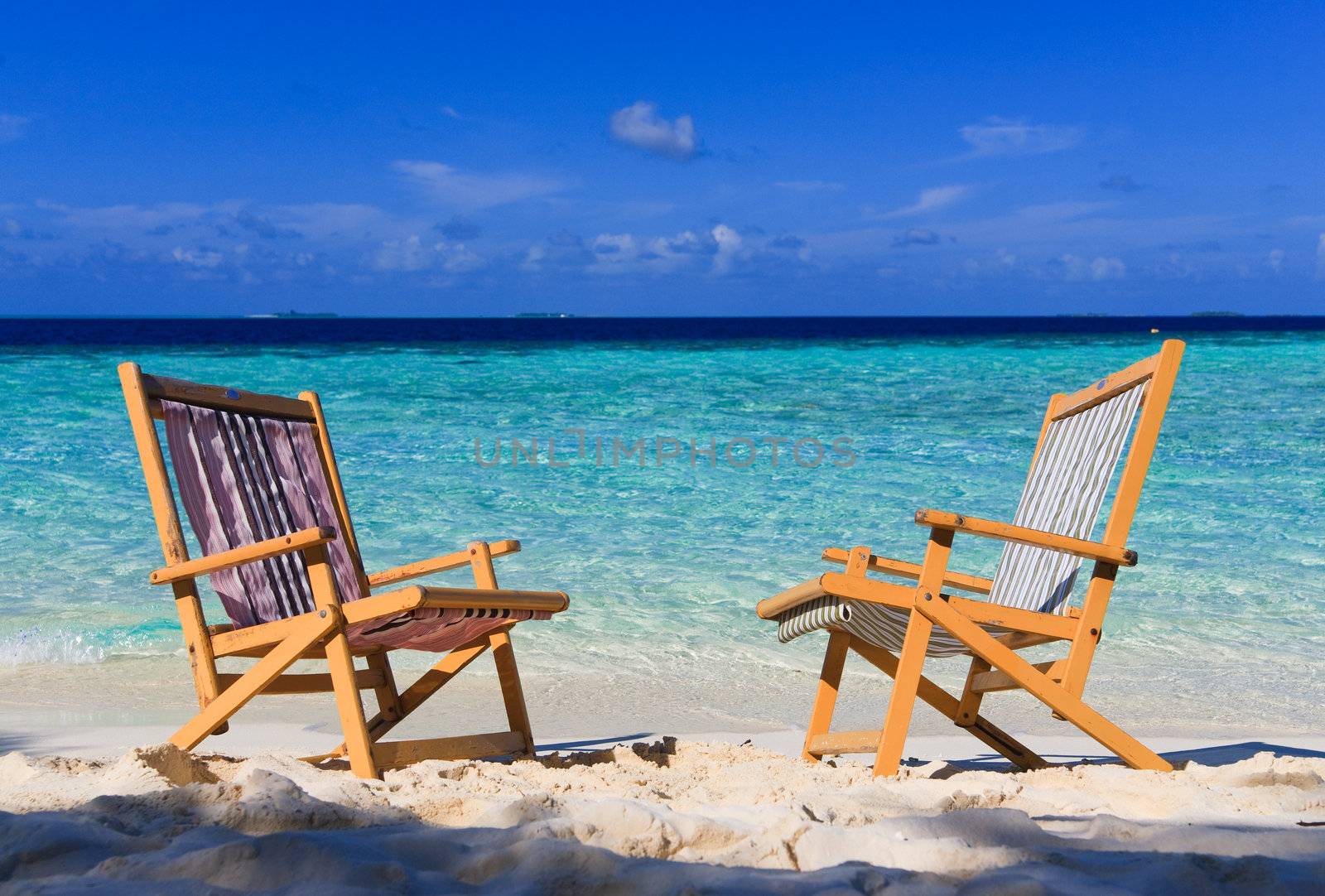 Relaxing on tropical paradise with white sand at Maldives and green palms with blue sky