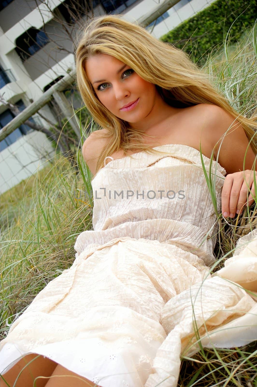young girl lying in the grass at the beach