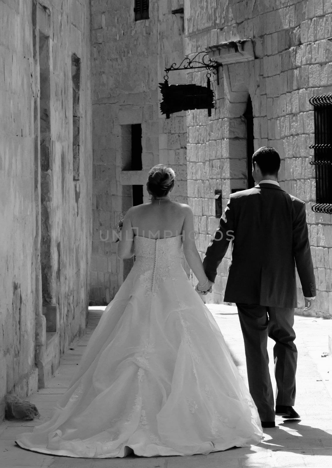 Newly wed couple walking in the old city streets in Malta