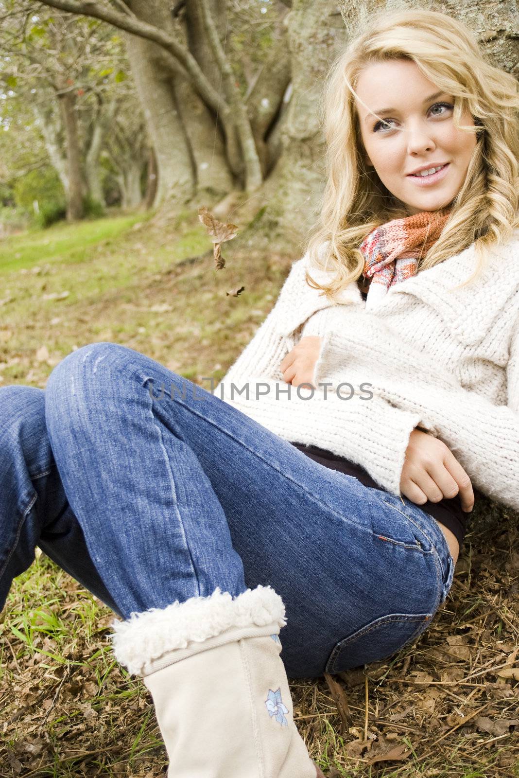 girl in the park leaning on a tree