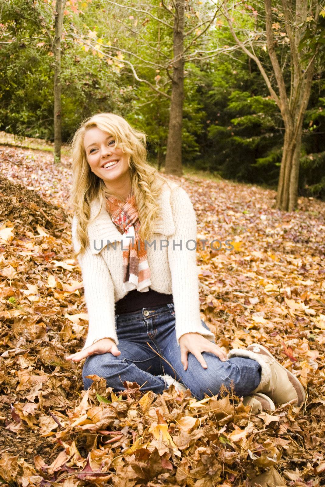 Young girl playing in the Autumn fall leaves