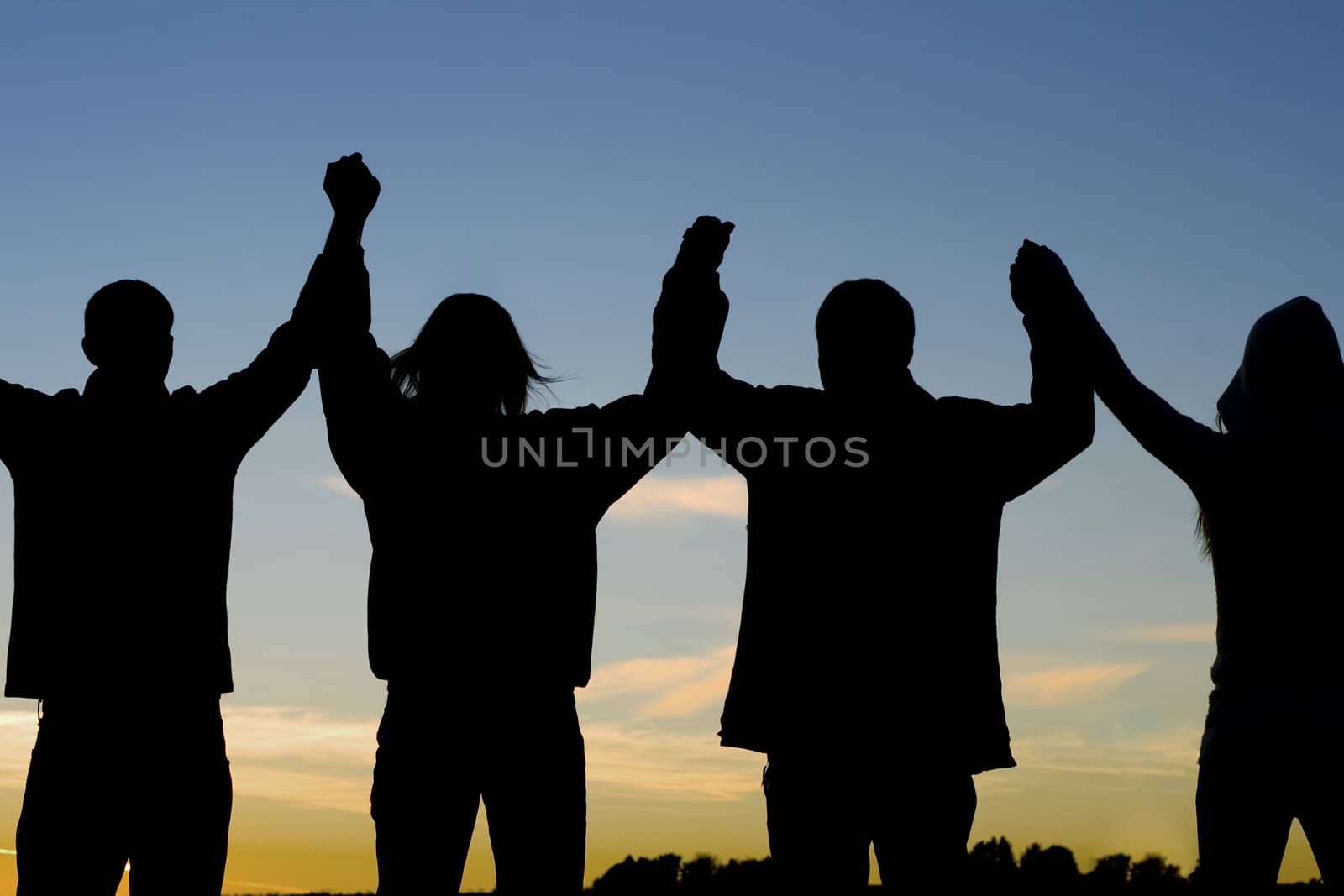 A group of people raise their arms together in cheering.
