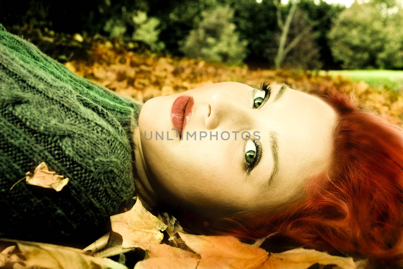 Beautiful woman in the park with the autumn leaves