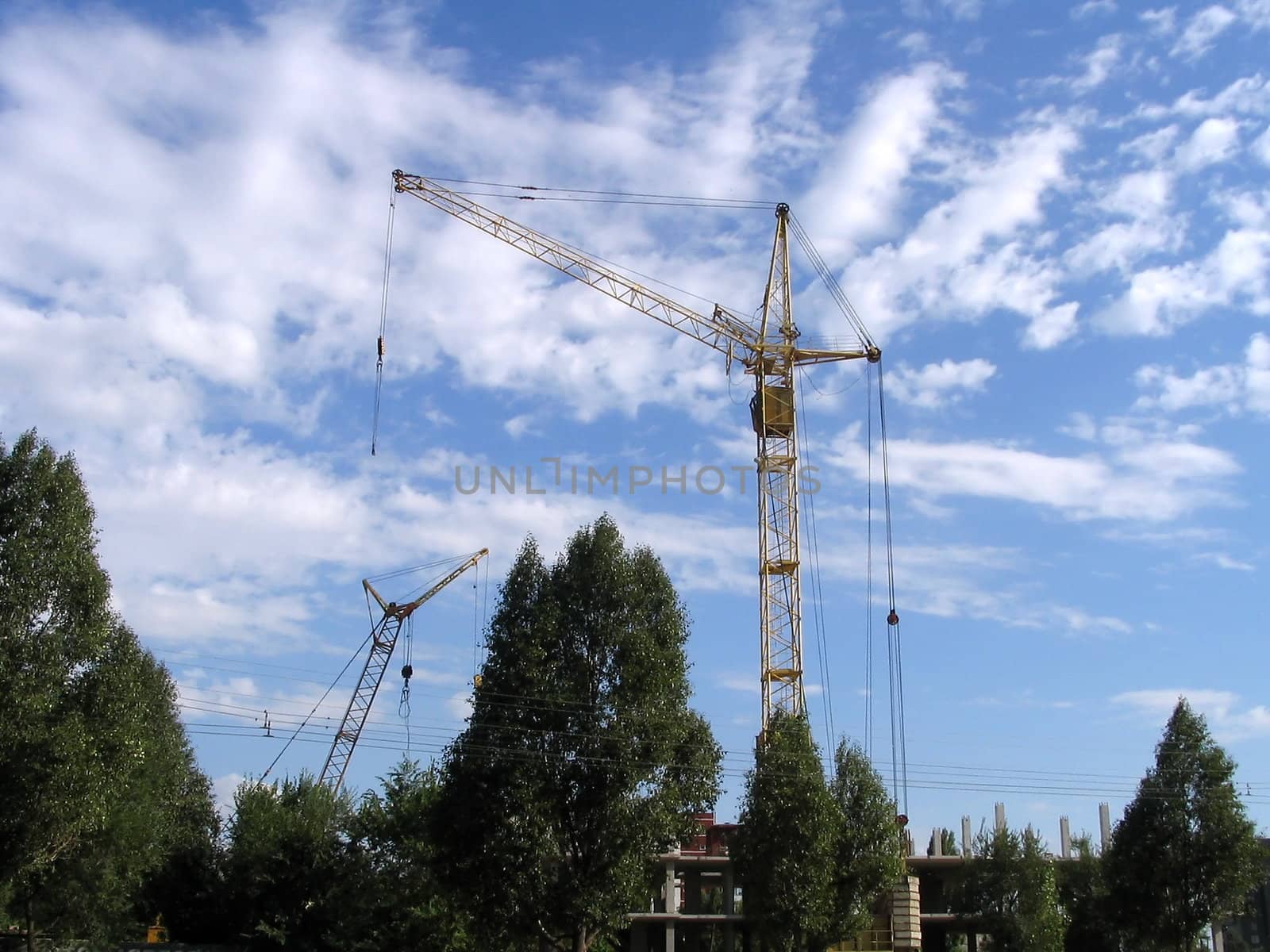 Lifting cranes on construction site on sky background