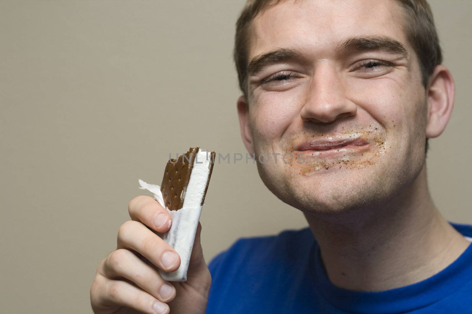 Young man enjoying an ice cream sandwhich. 