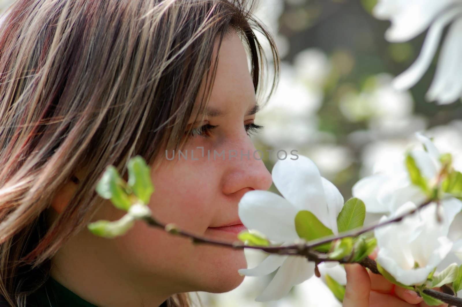 attractive girl smell flower in park