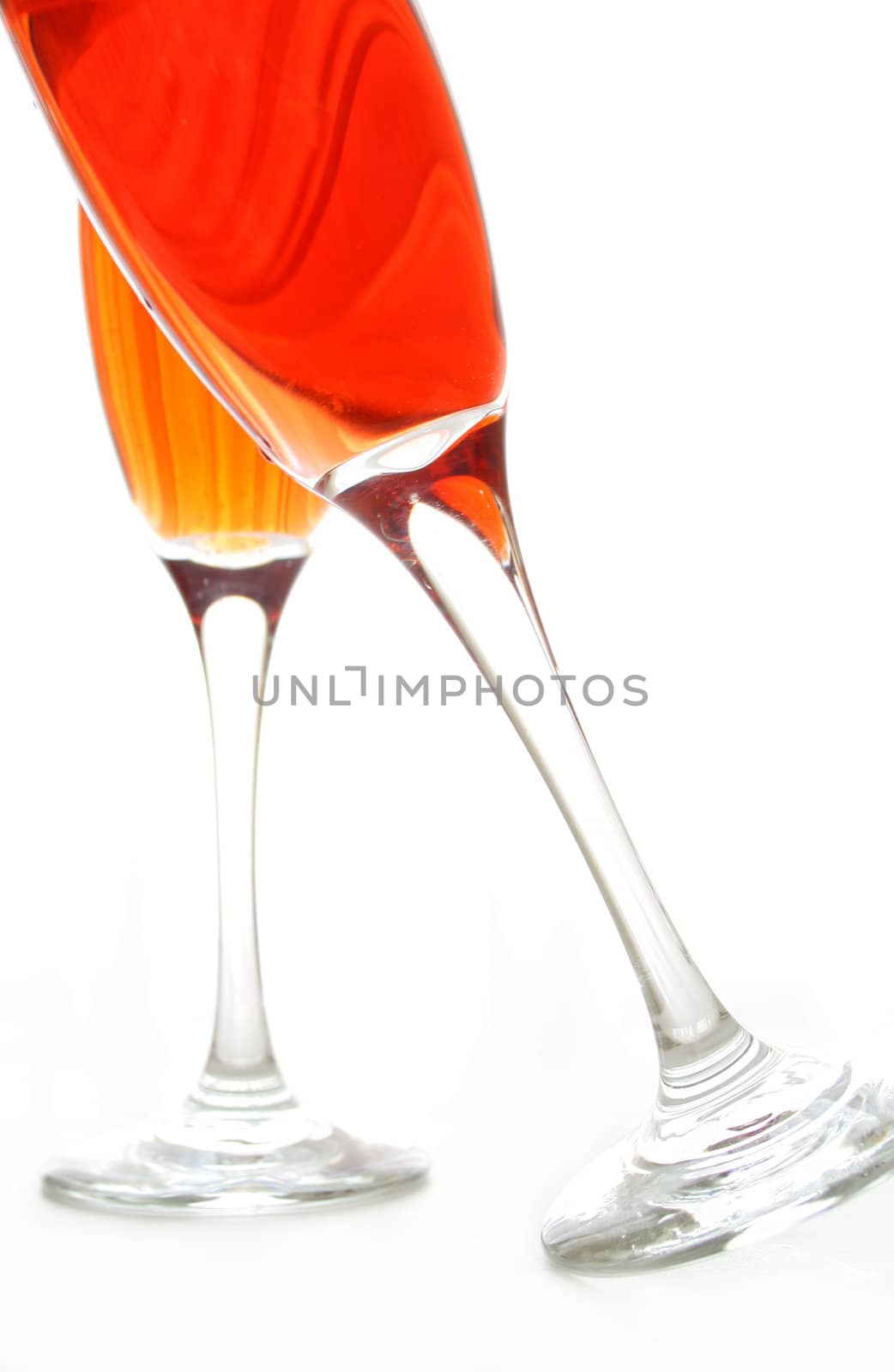 Two wine glasses full of wine and one glass leaning into the other. All isolated on a white background.