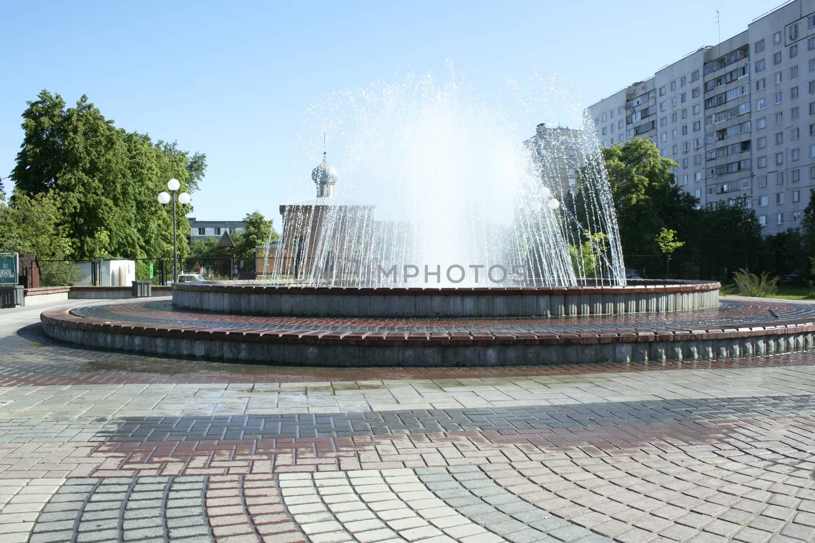 Fountain in the city with church on the background.