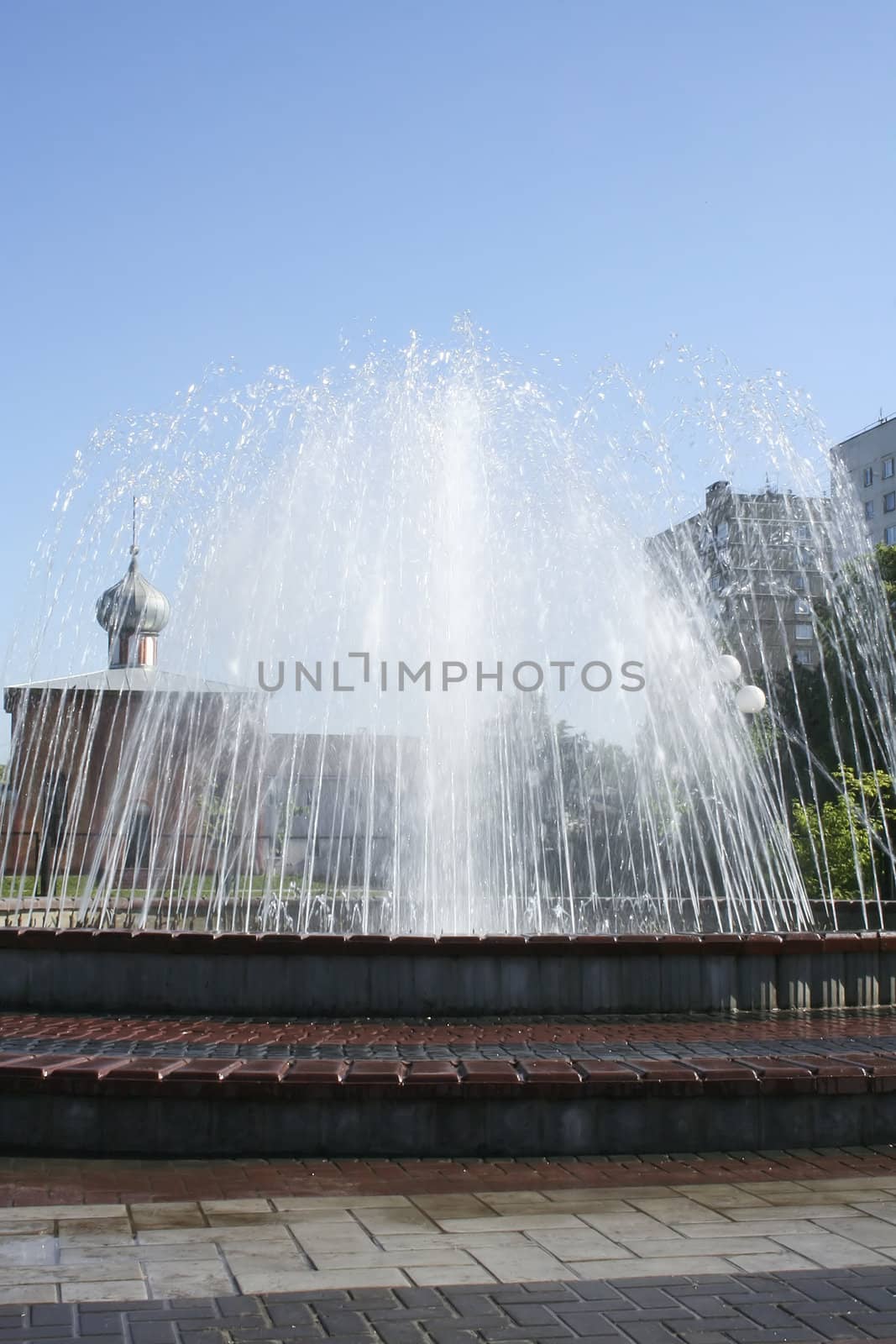 Fountain in the city with church on the background.