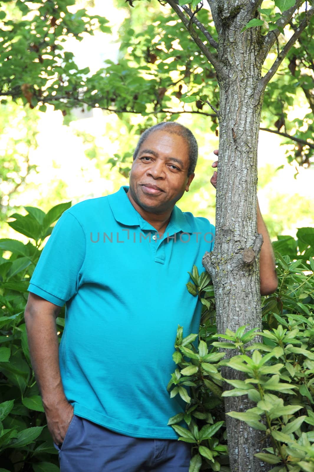 African american man standing next to a tree.