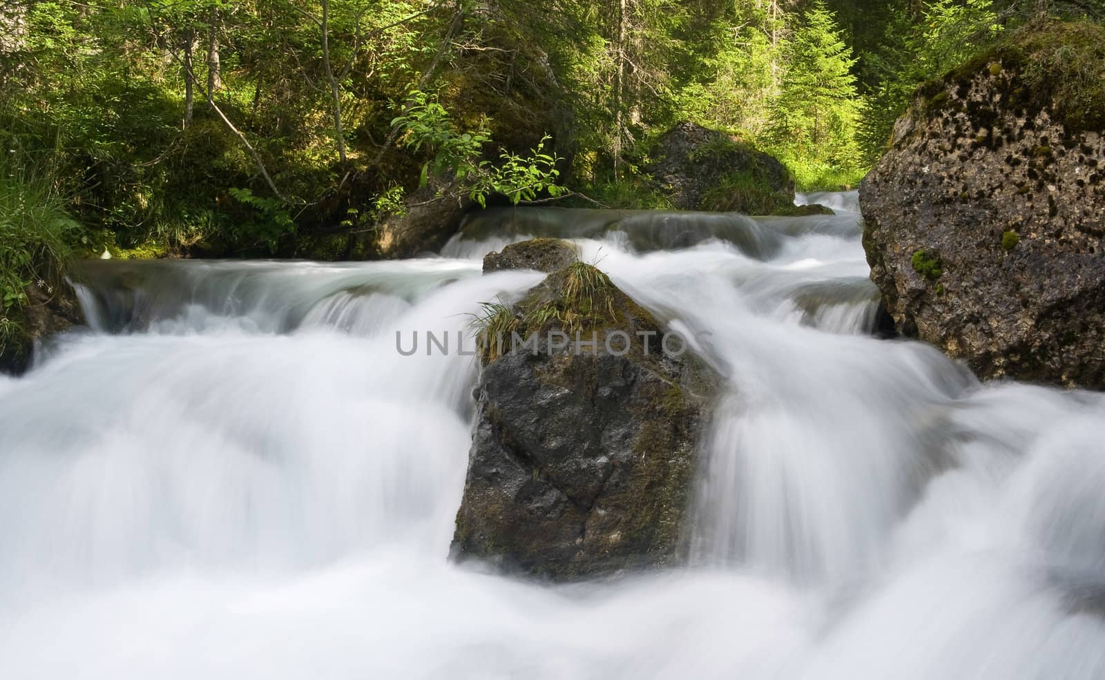 beautiful nature scene with river and waterfall at summer in val di Fassa, italian Dolomites