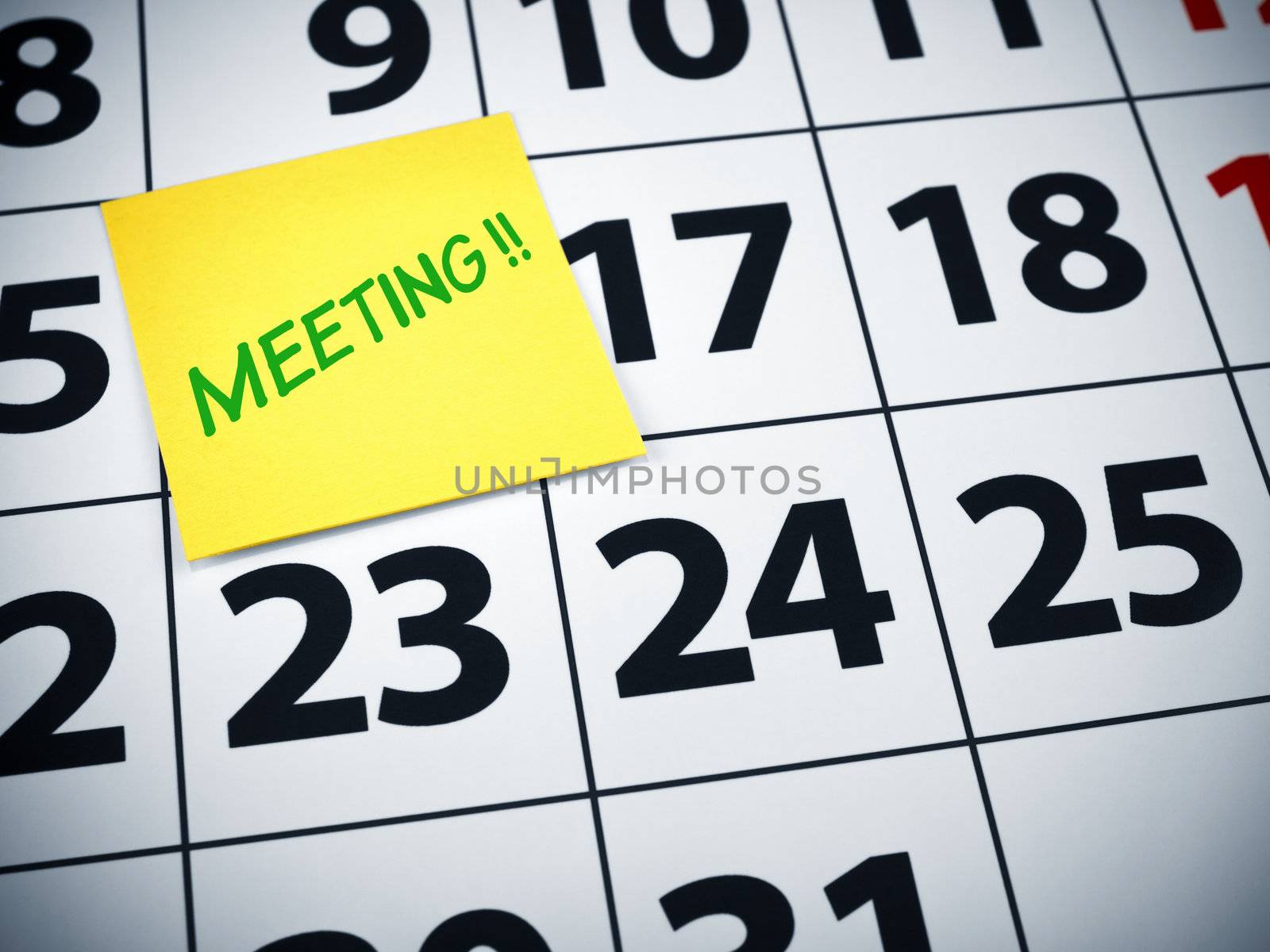 Meeting written on a sticky note on a calendar.