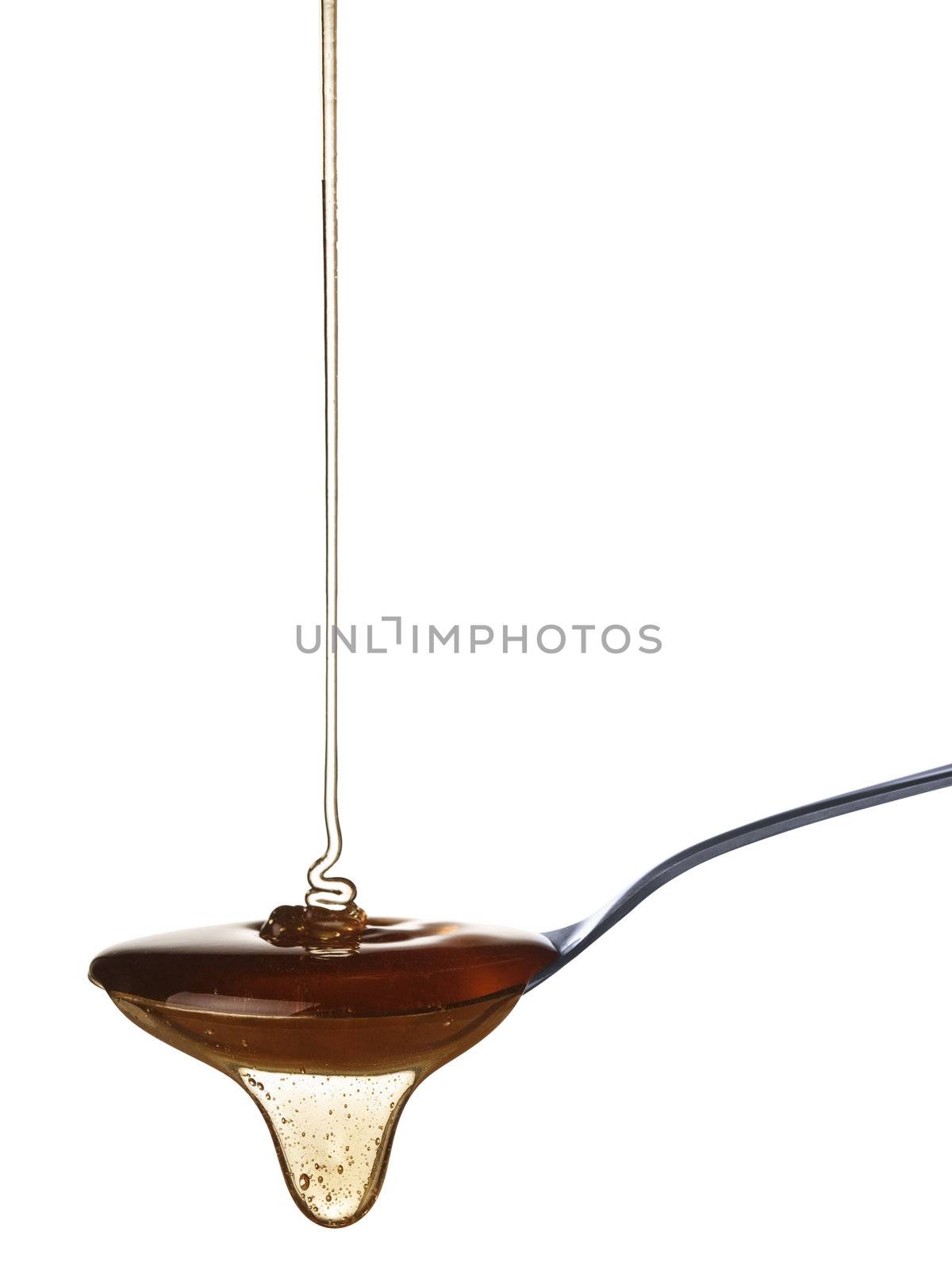 The honey slowly falls onto the spoon.