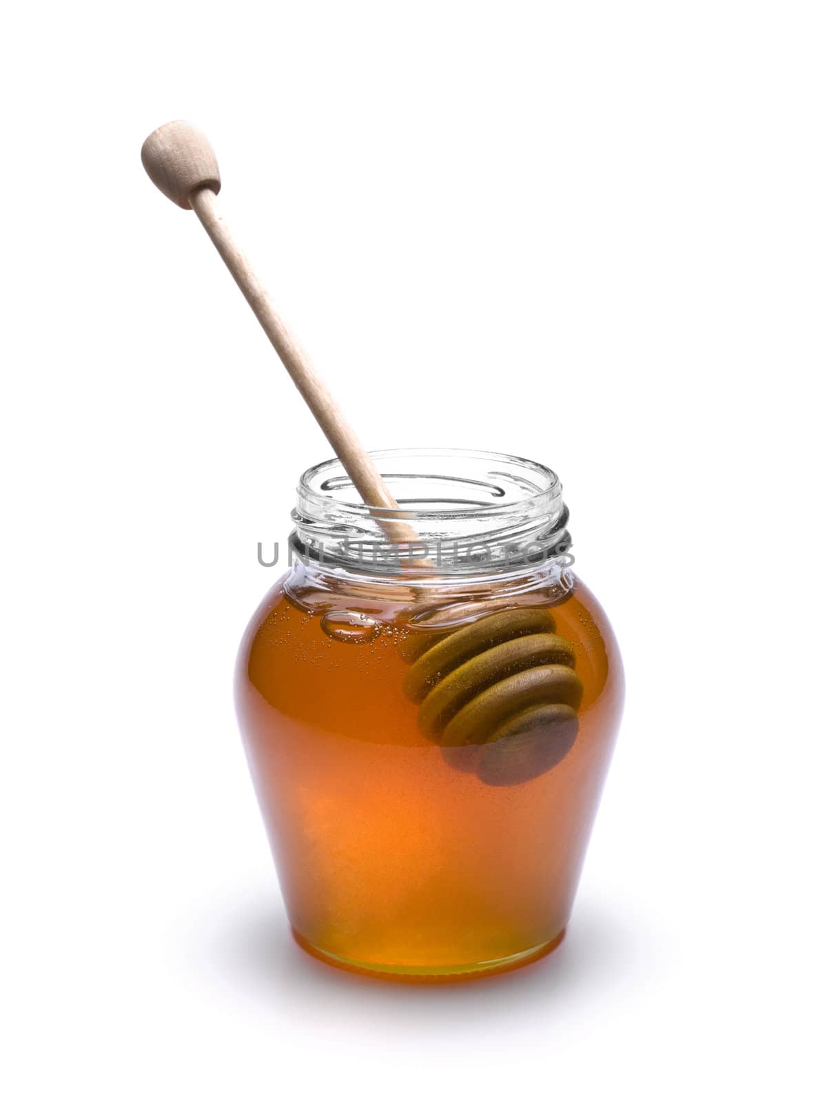 Jar of honey with a wooden drizzler inside. Isolated on white background.