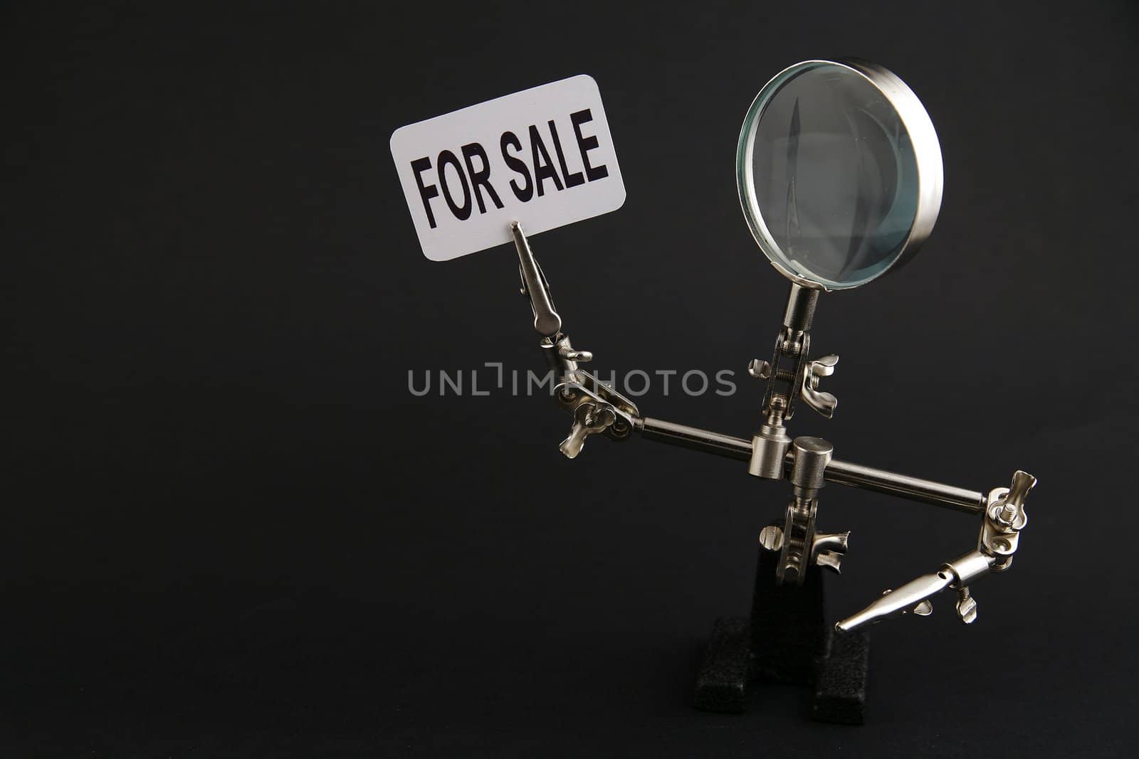 figure of steel man with "for sale" inscription on black background
