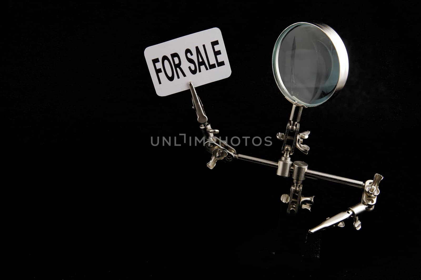 figure of steel man with "for sale" inscription on black background