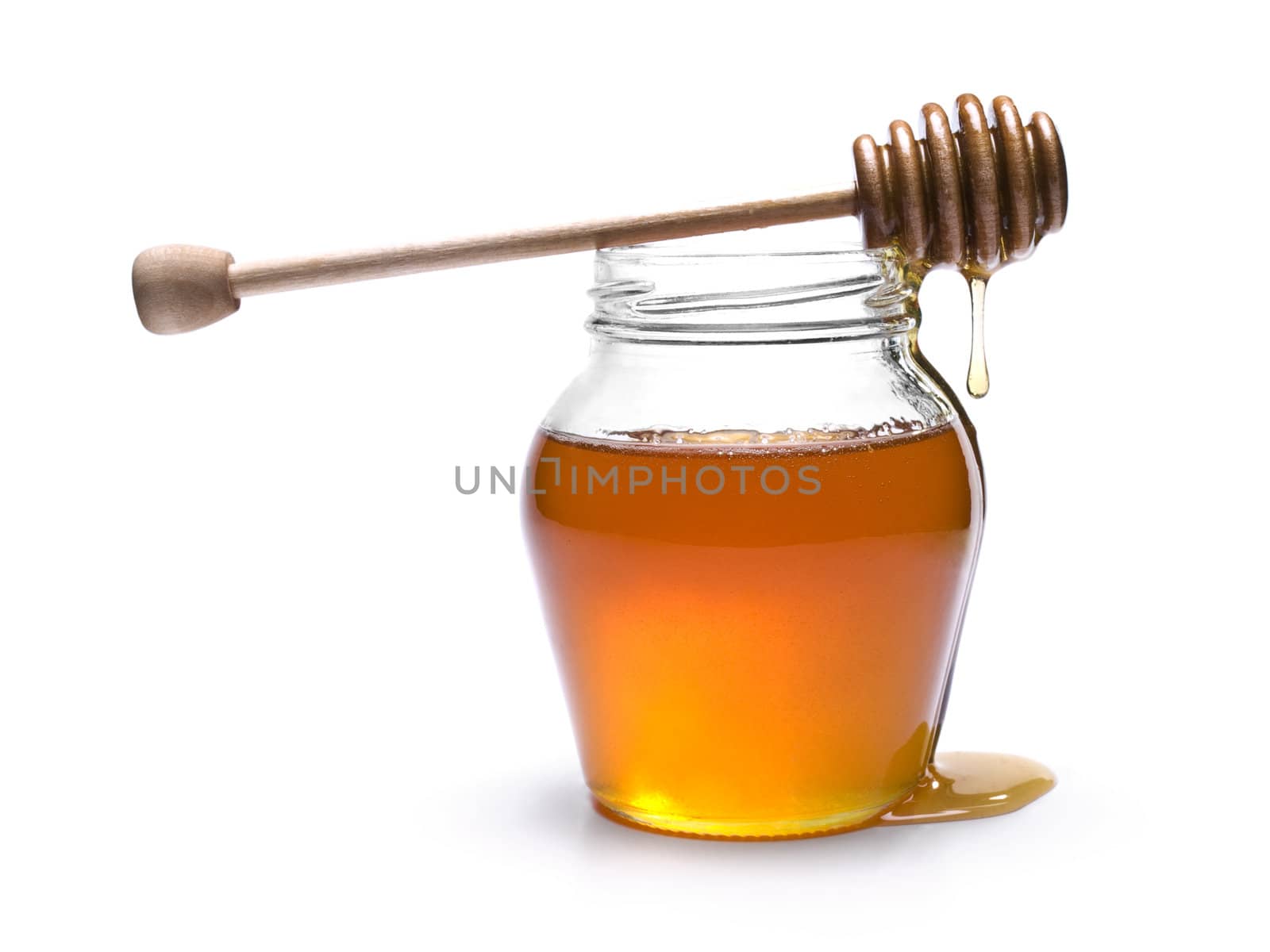 Jar of honey with a wooden drizzler on top. Isolated on white background.