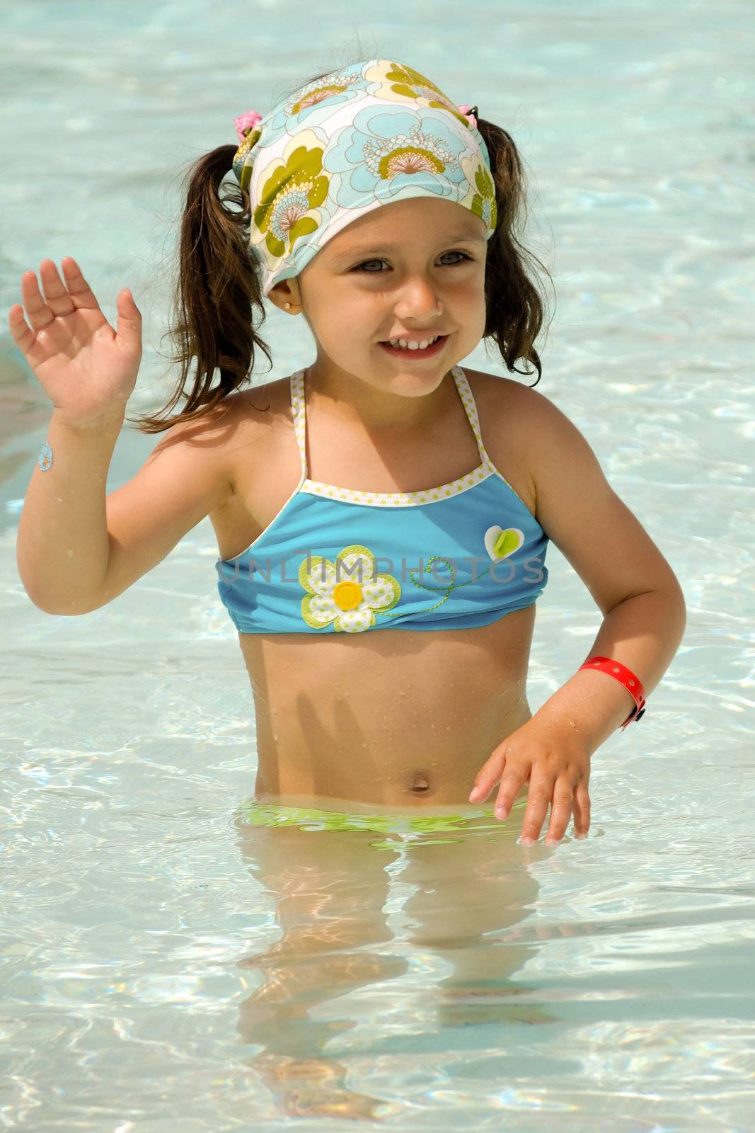Happy child waving in pool