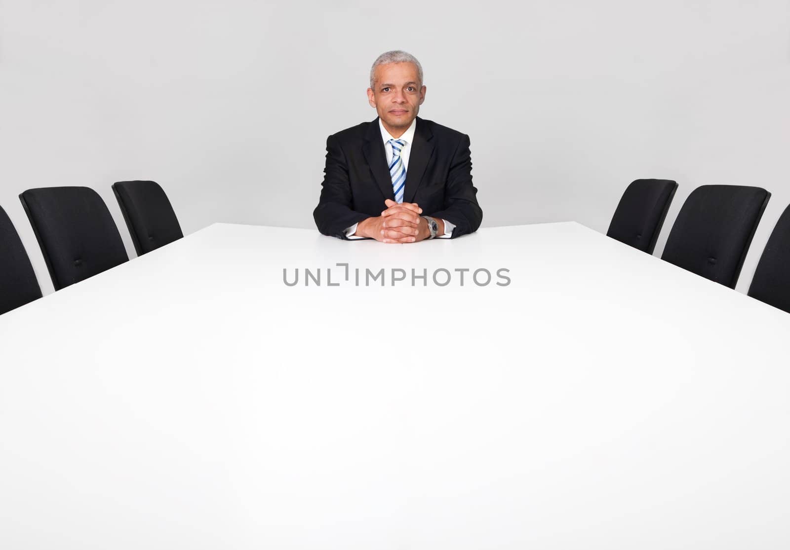 Businessman sitting alone in the empty boardroom