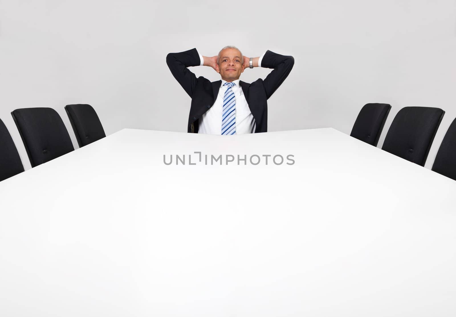 Businessman sitting alone in the empty boardroom