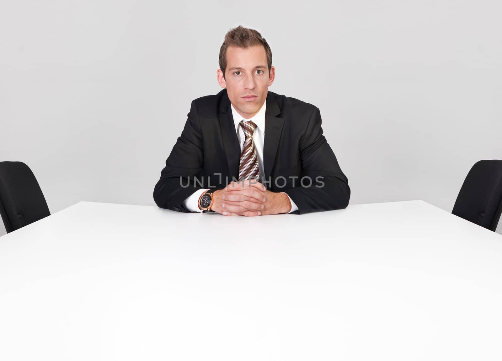 Businessman sitting alone in the empty boardroom