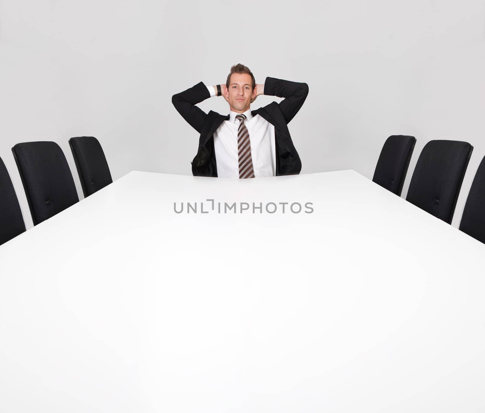 Businessman sitting alone in the empty boardroom