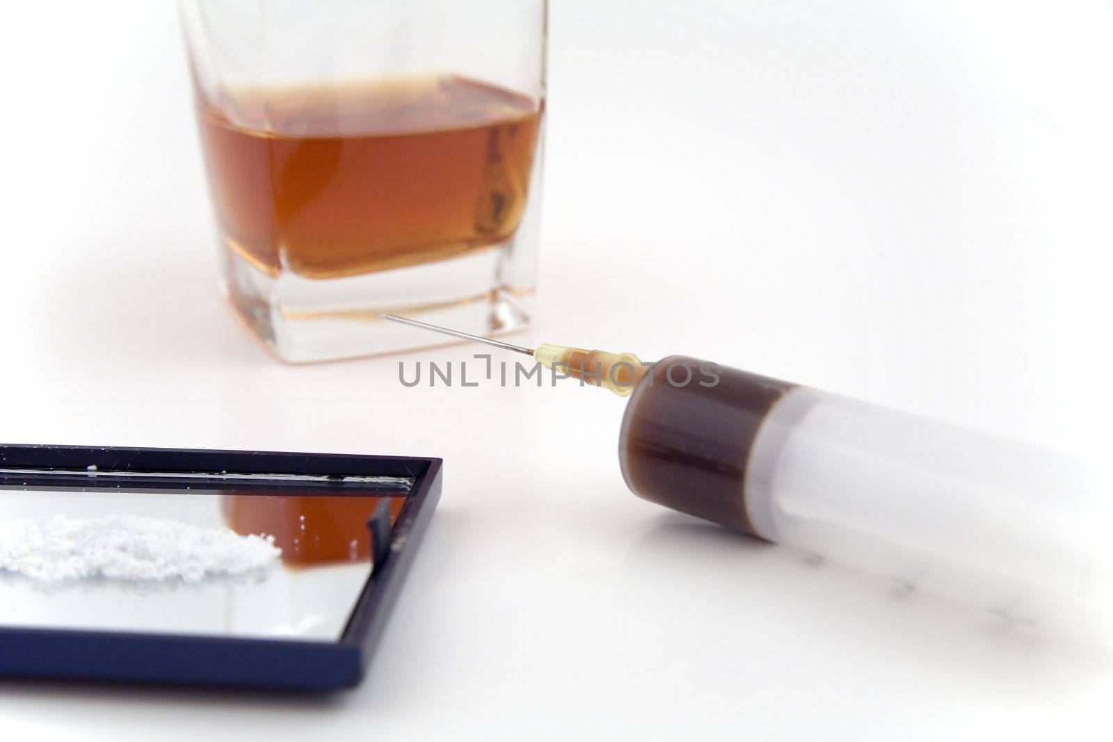 syringe, cocaine and a glass of whiskey