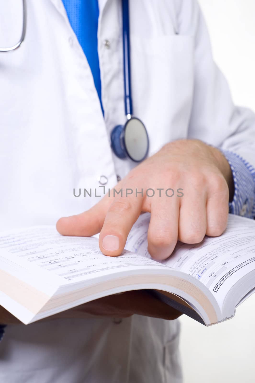 male doctor with stethoscope reading medical book