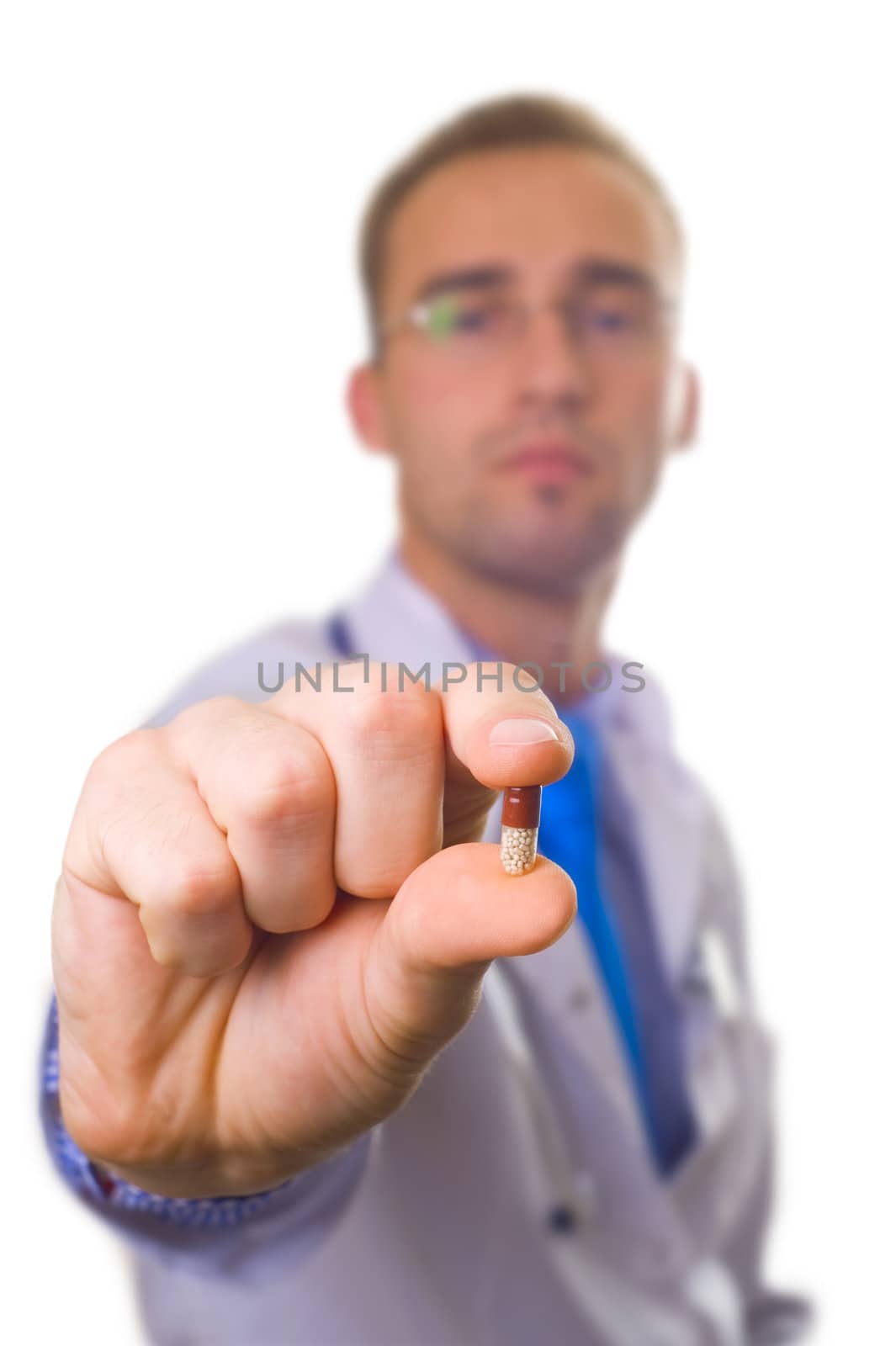 male caucasian doctor holding pill in fingers