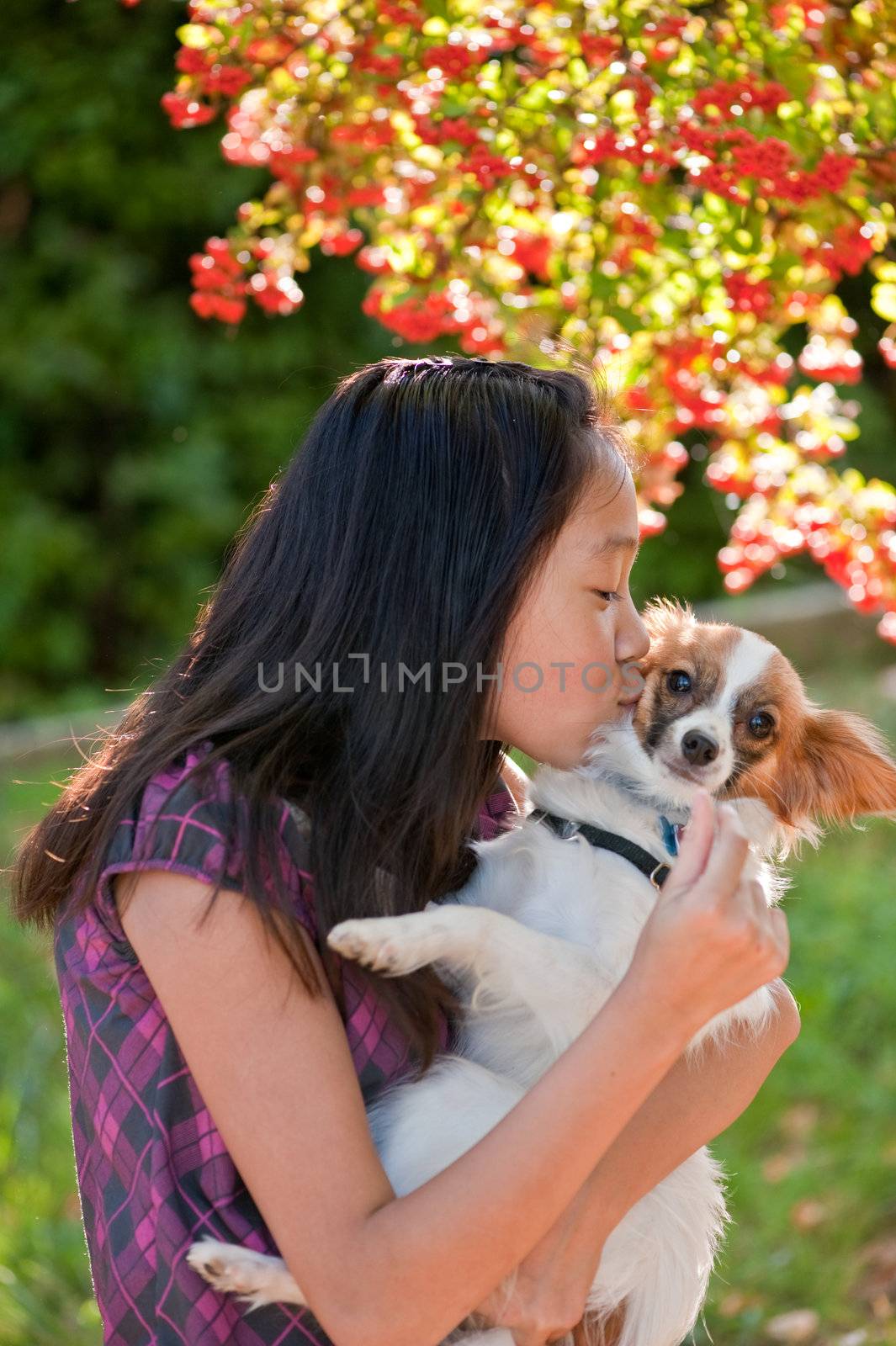 An Asian girl is playing with her dog at Luther Burbank park