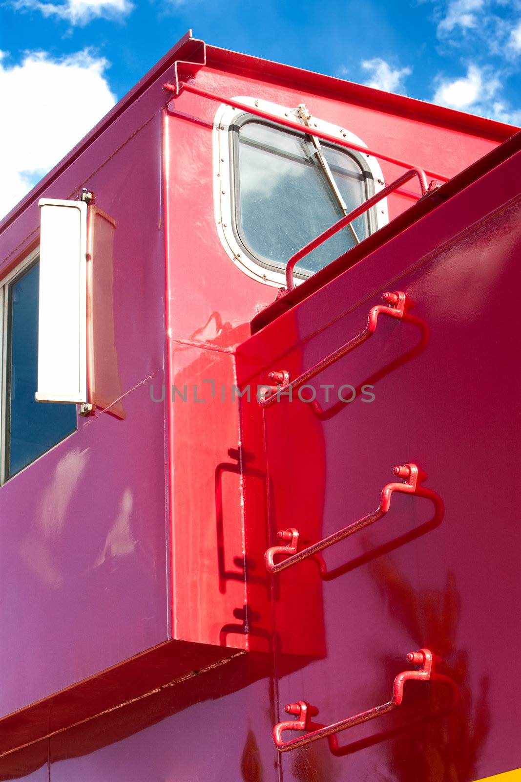 Detail of red train caboose against blue sky