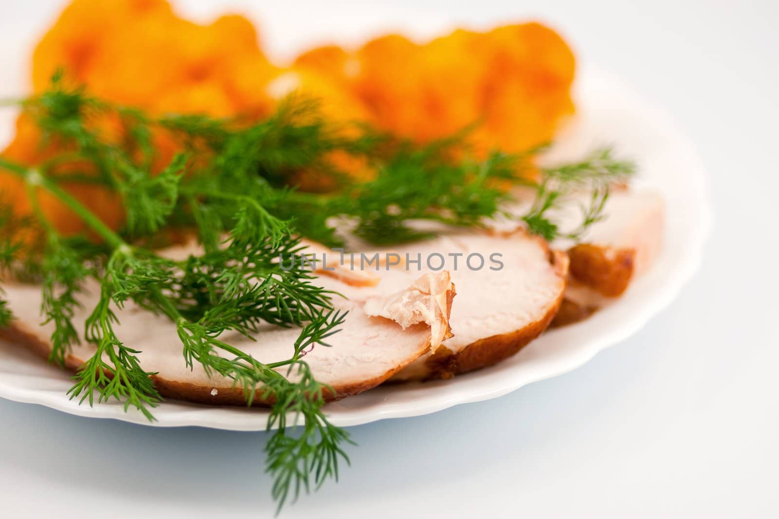 Rosted cauliflower with hot smoked chiken meat and fresh dill on white porcelain plate. 
Short depth of field (DOF) version at aperture F2.8.