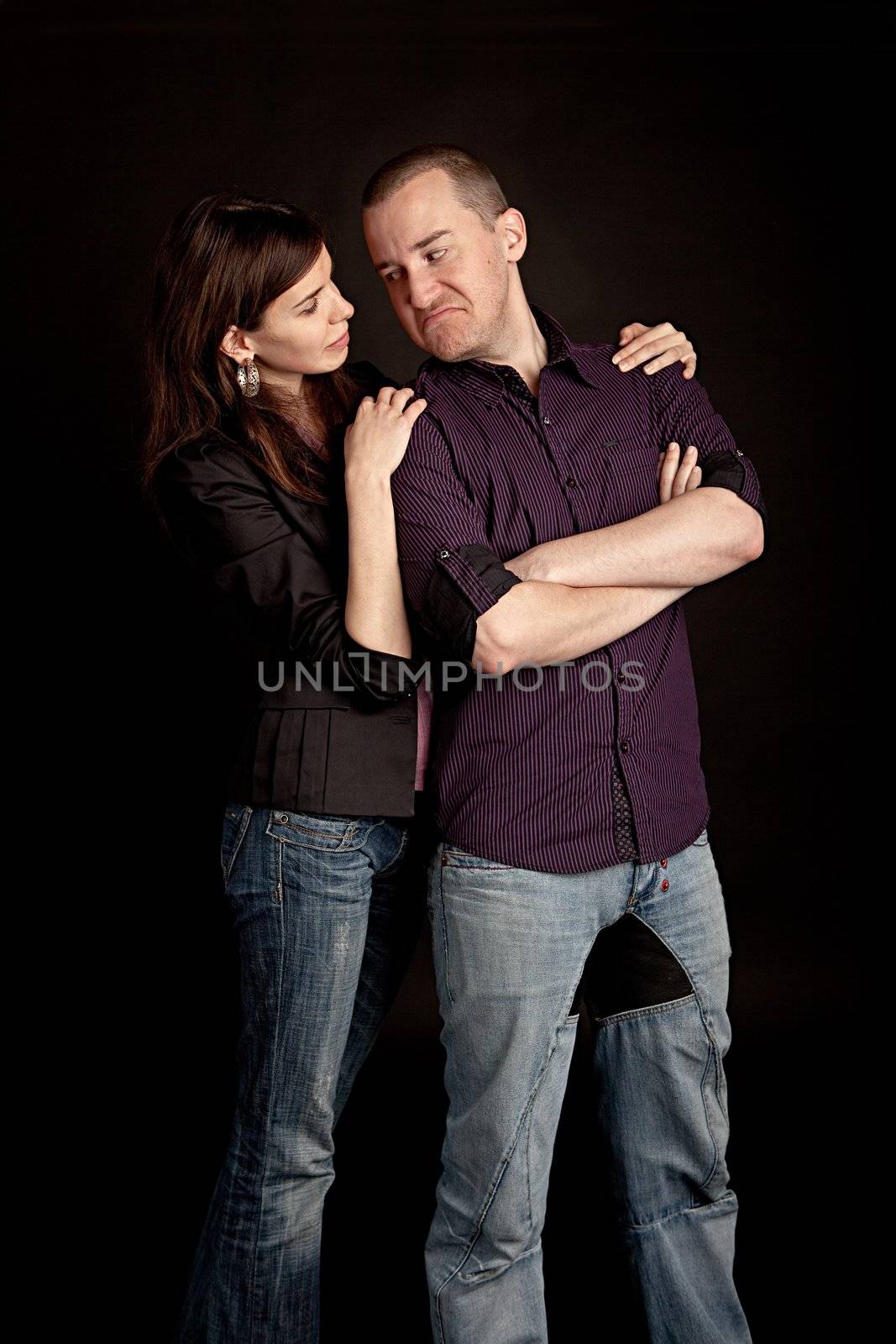 Woman embracing her sad boyfriend. Studio shot