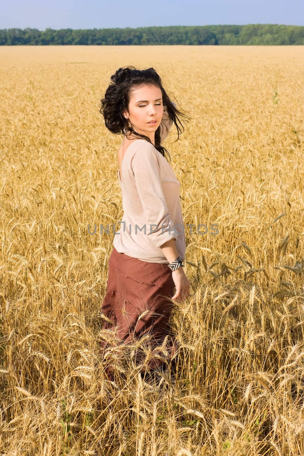 Attractive girl standing in wheat field by rozhenyuk