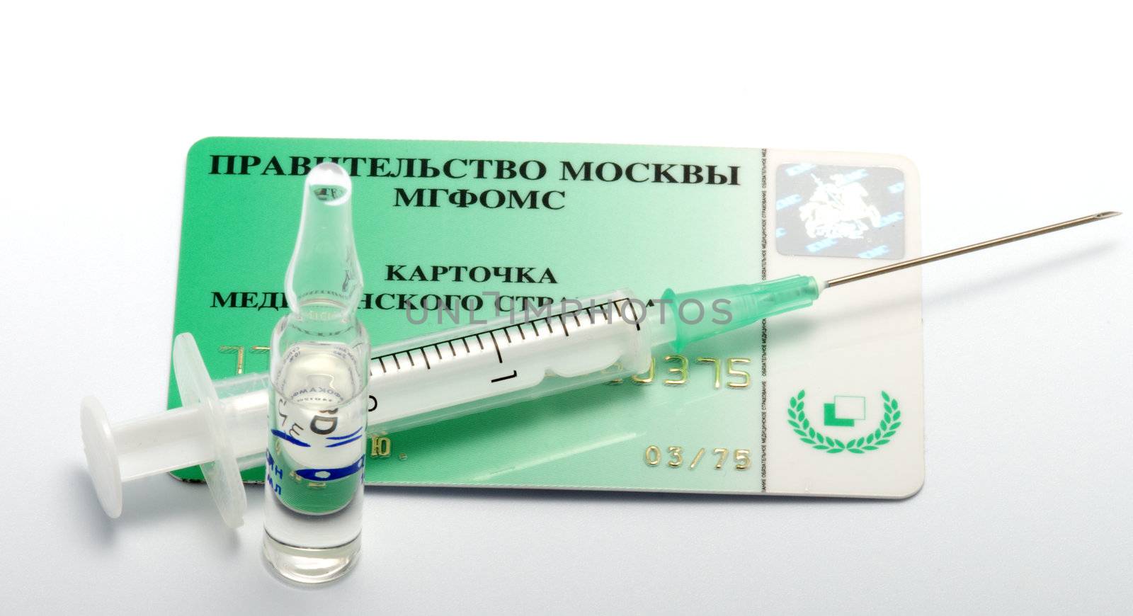 Card of medical insurance and syringe with an ampoule.