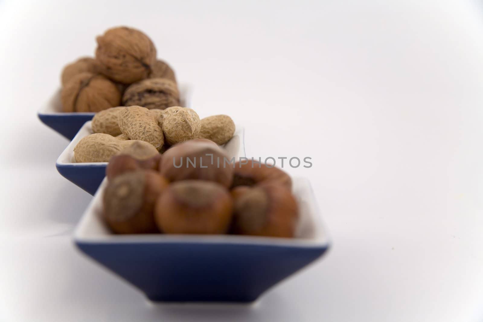 walnuts, hazelnuts and peanuts in three bowls by furzyk73