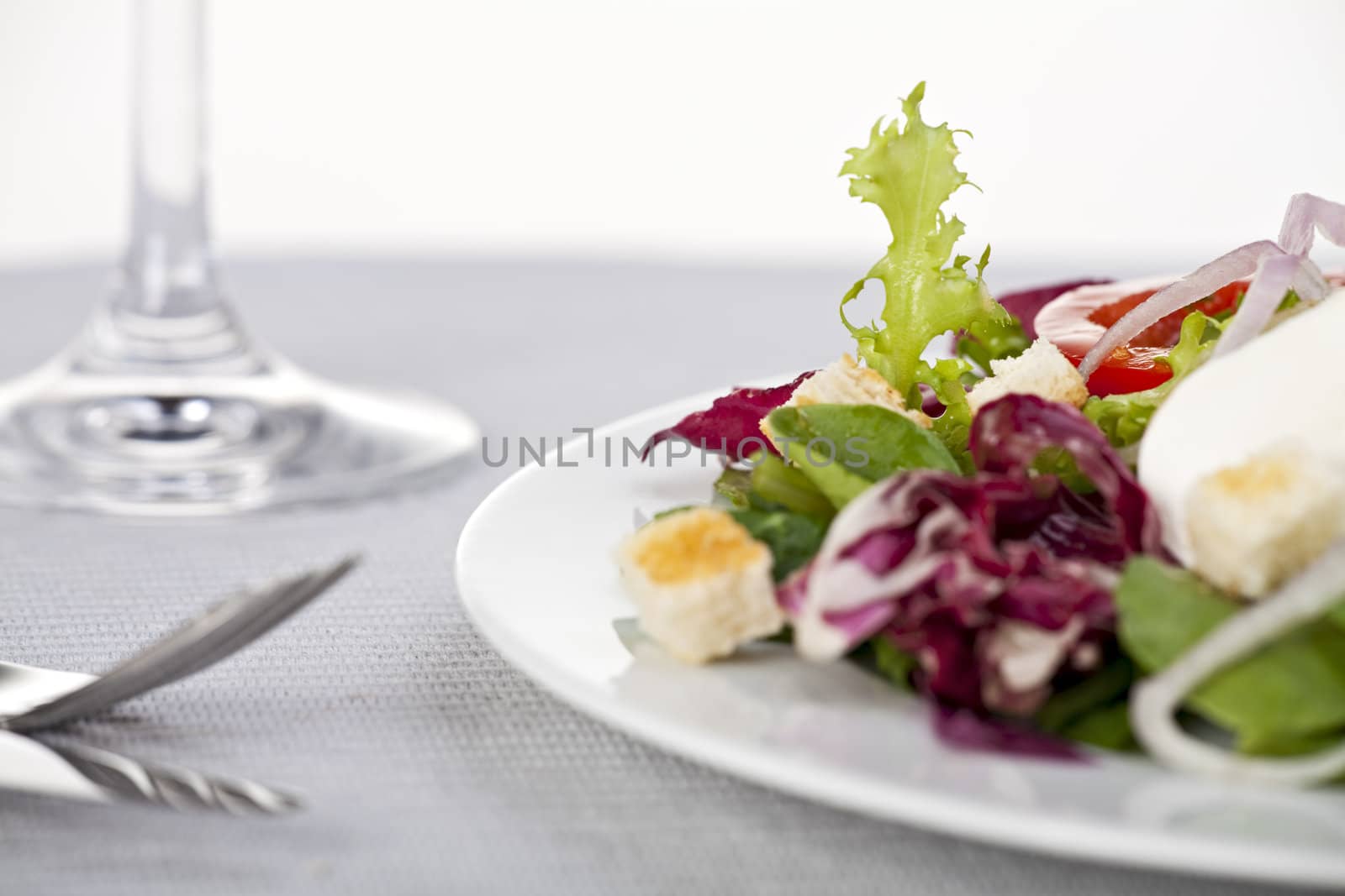 mixed salad, a fork and a knife