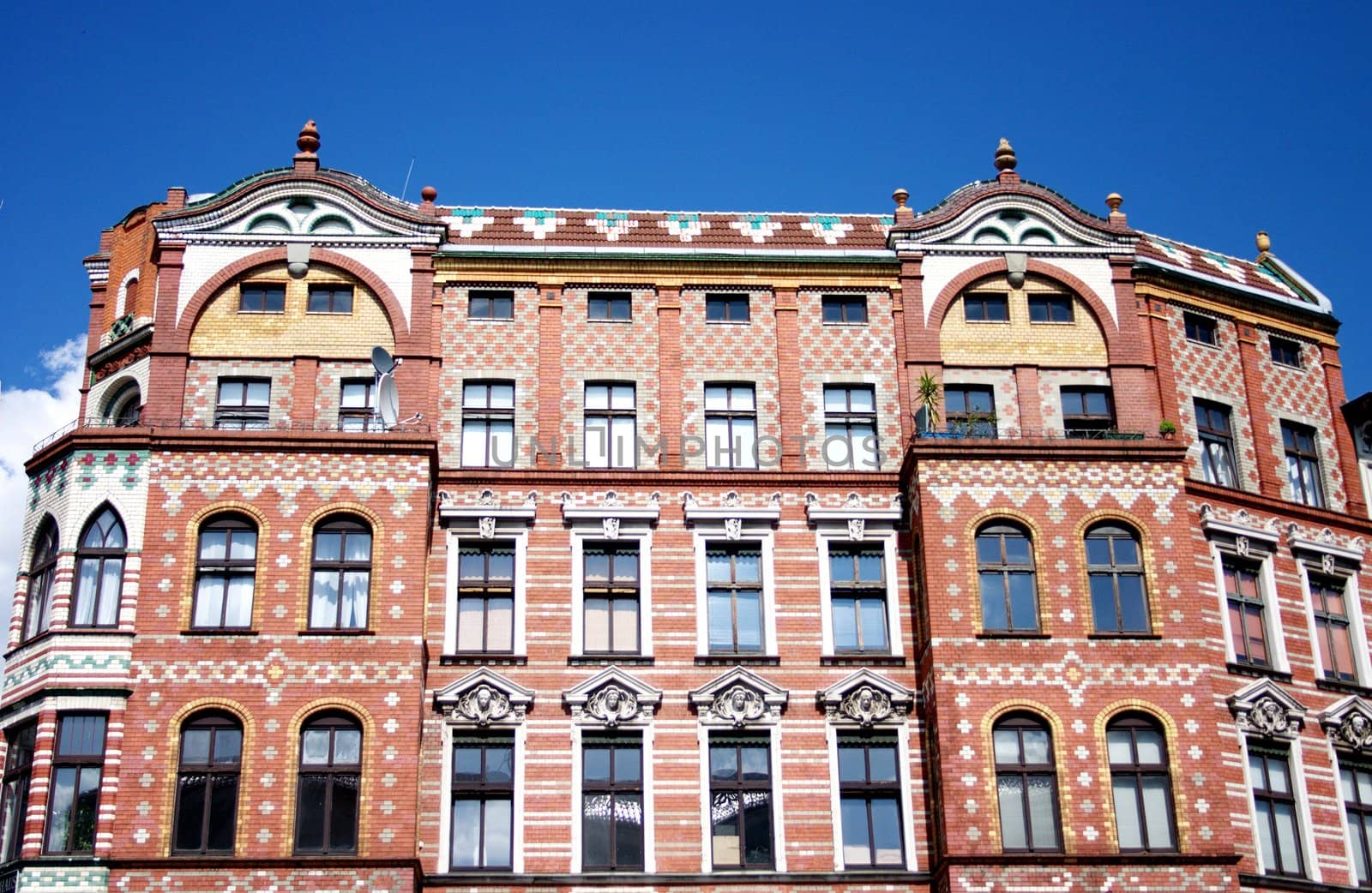 The old brick red house with windows on street in clear weather