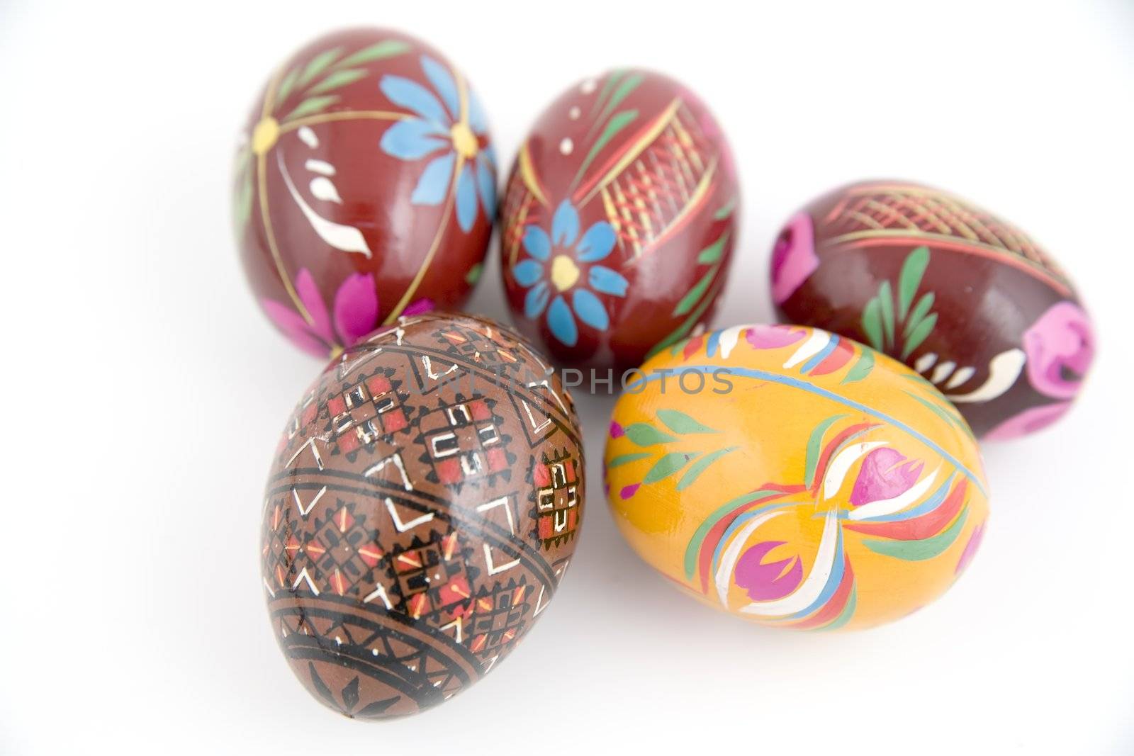 five painted eggs in basket on whie background