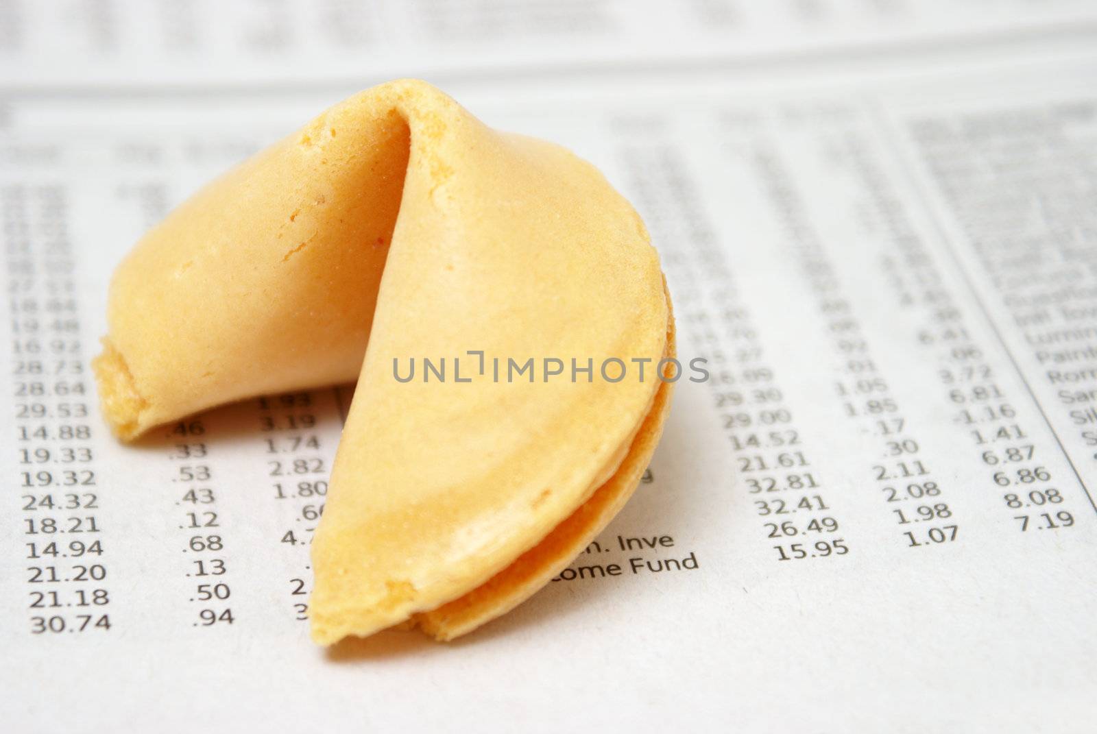 A fortune cookie on the stock investment section of a newspaper.