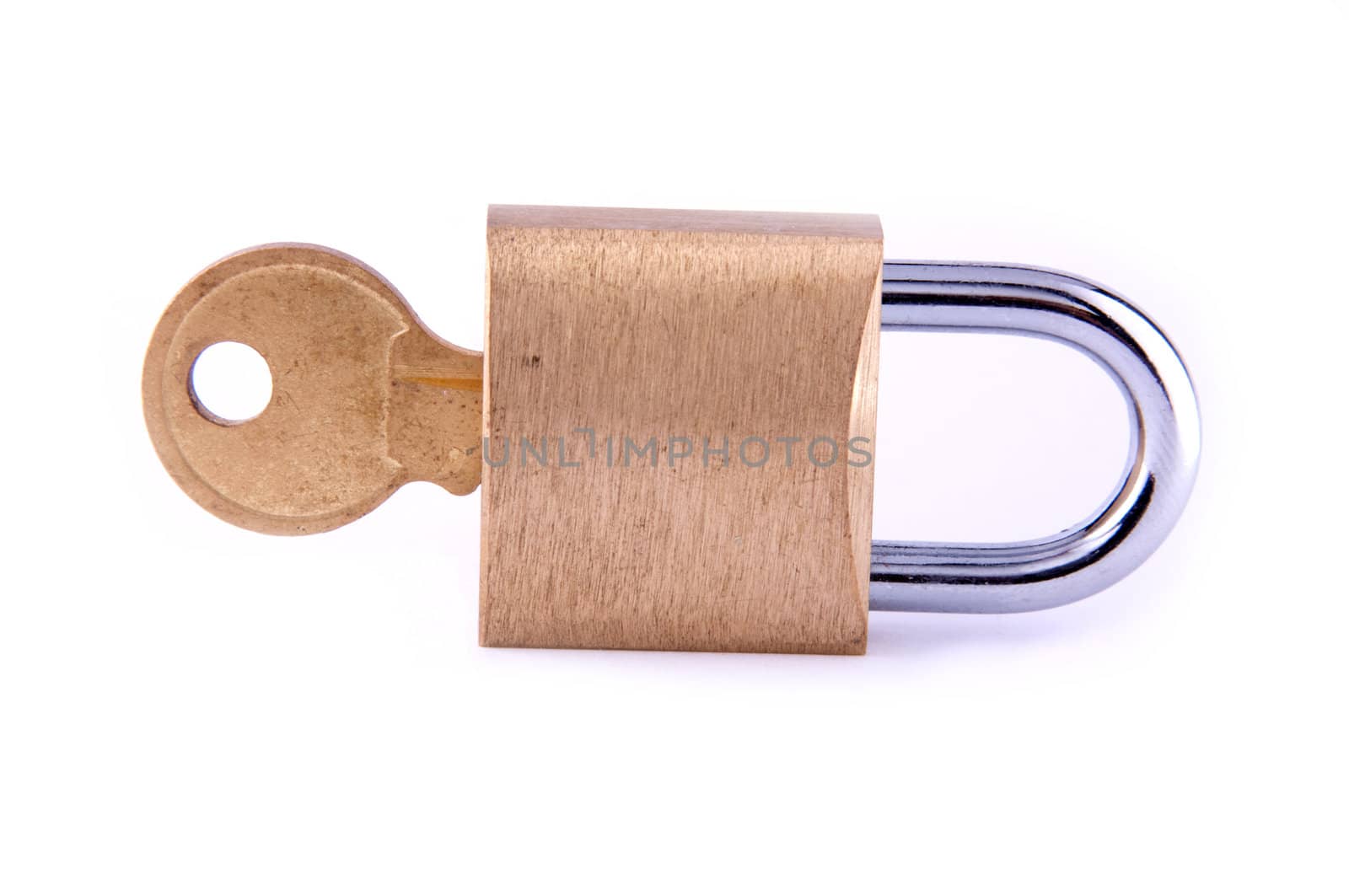 A brass padlock with inserted key, isolated on white