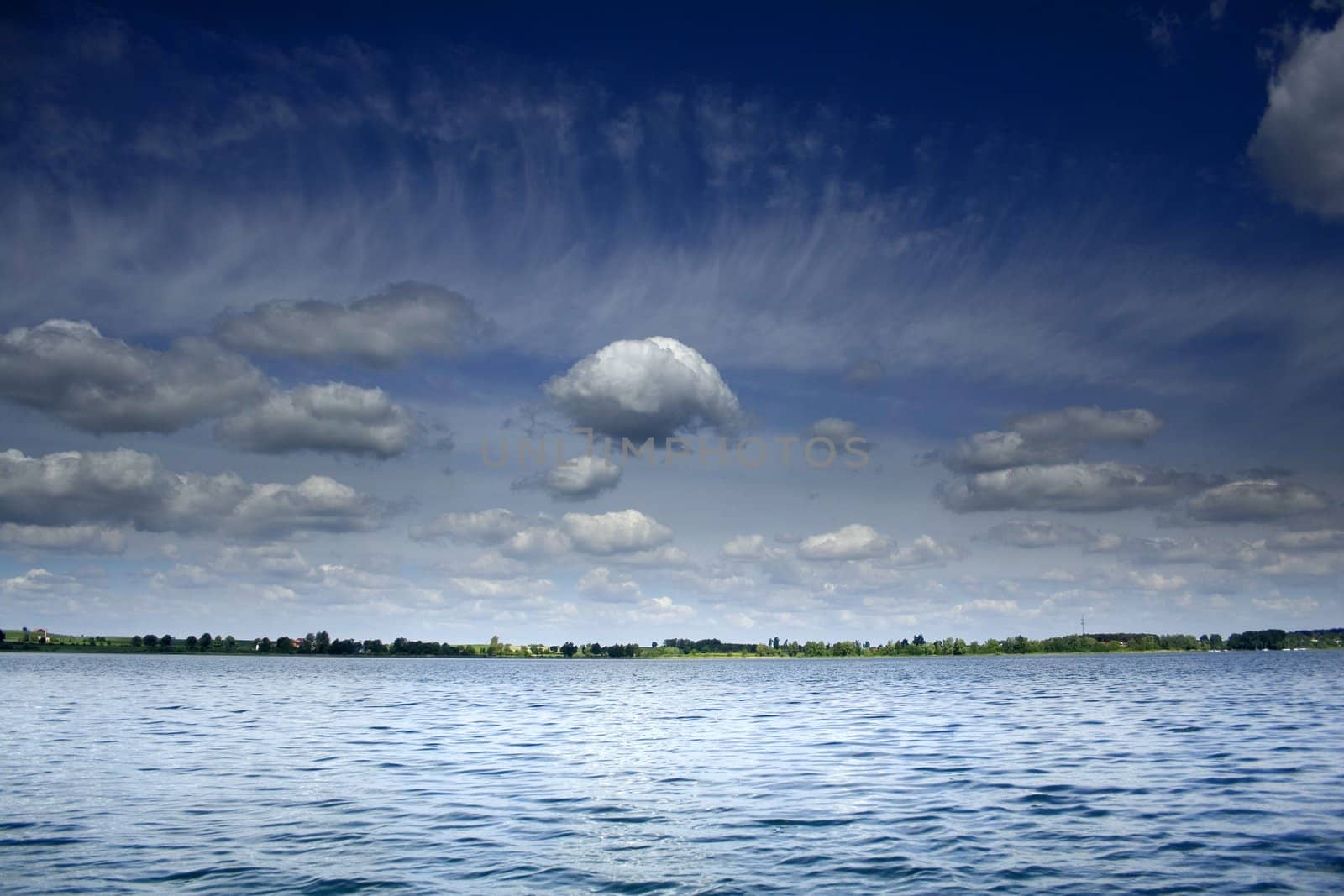 white clouds on the blue sky over the lake by furzyk73