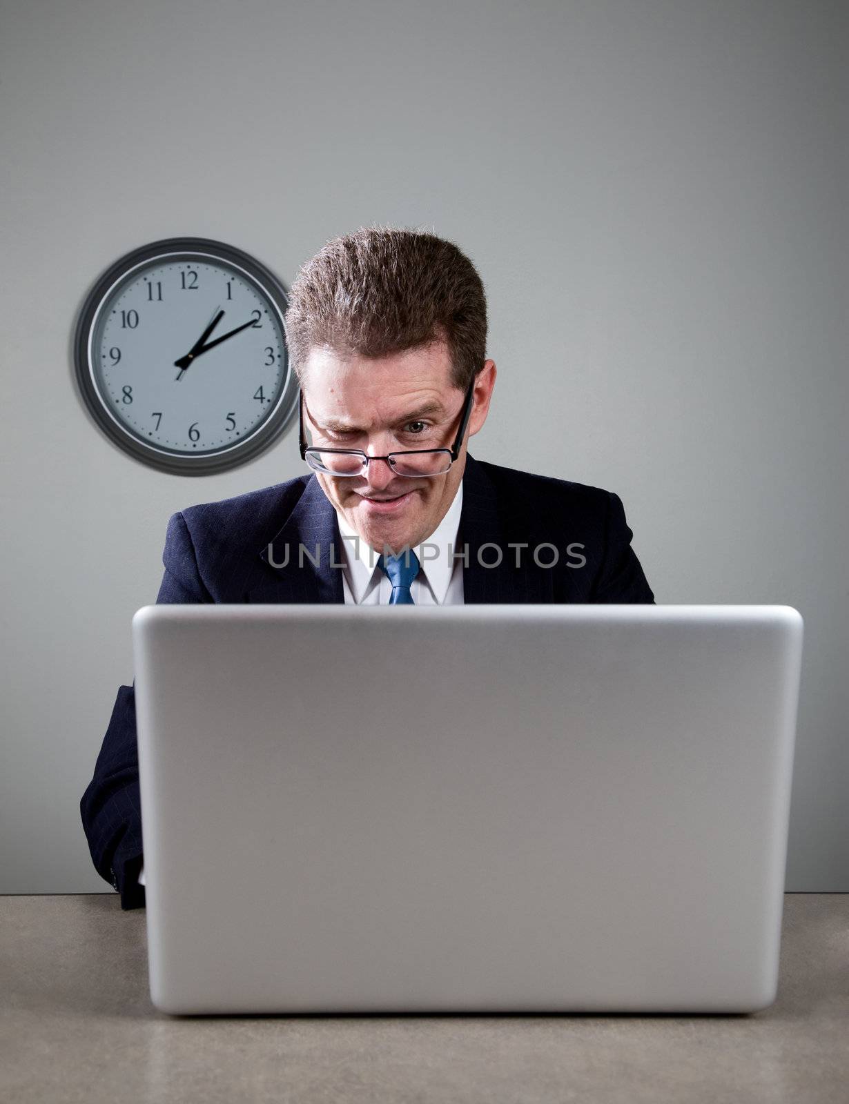 Crazy businessman working late at desk on laptop computer