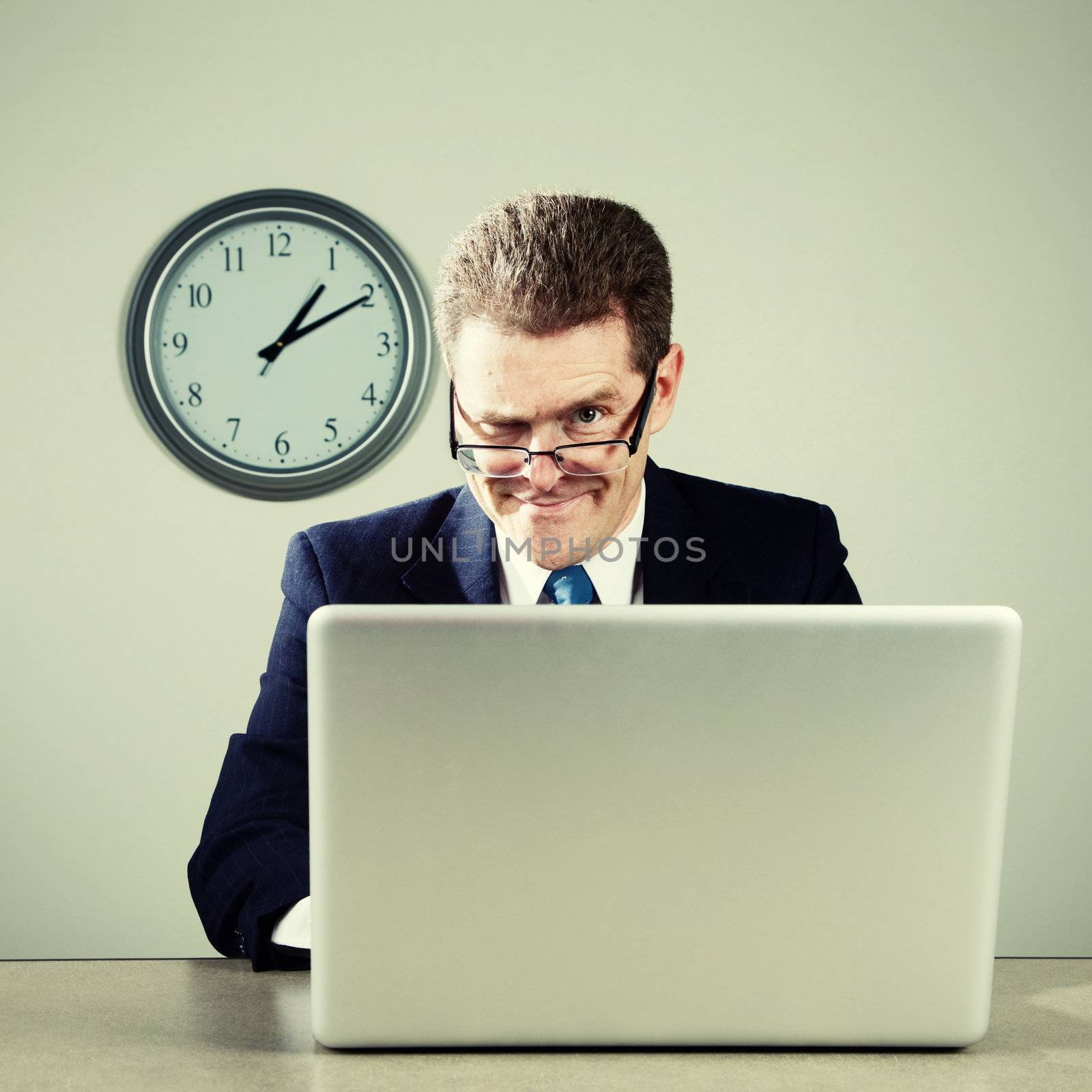 Crazy businessman working late at desk on laptop computer