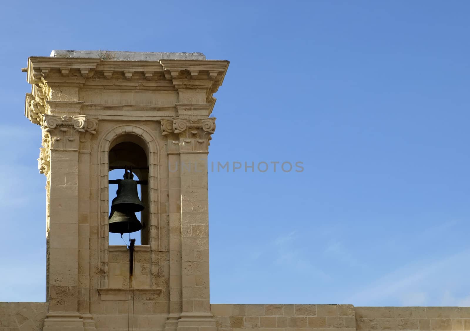 A medieval clocktower against blue sky and clouds