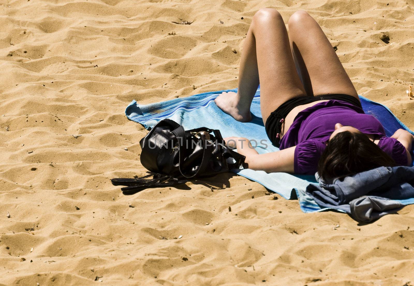 Woman sunbathing on a beach in spring in Malta