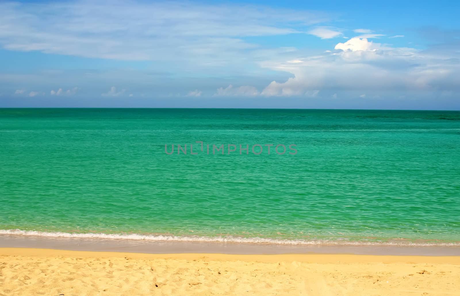 Simple composition: ocean over blue sky and sand