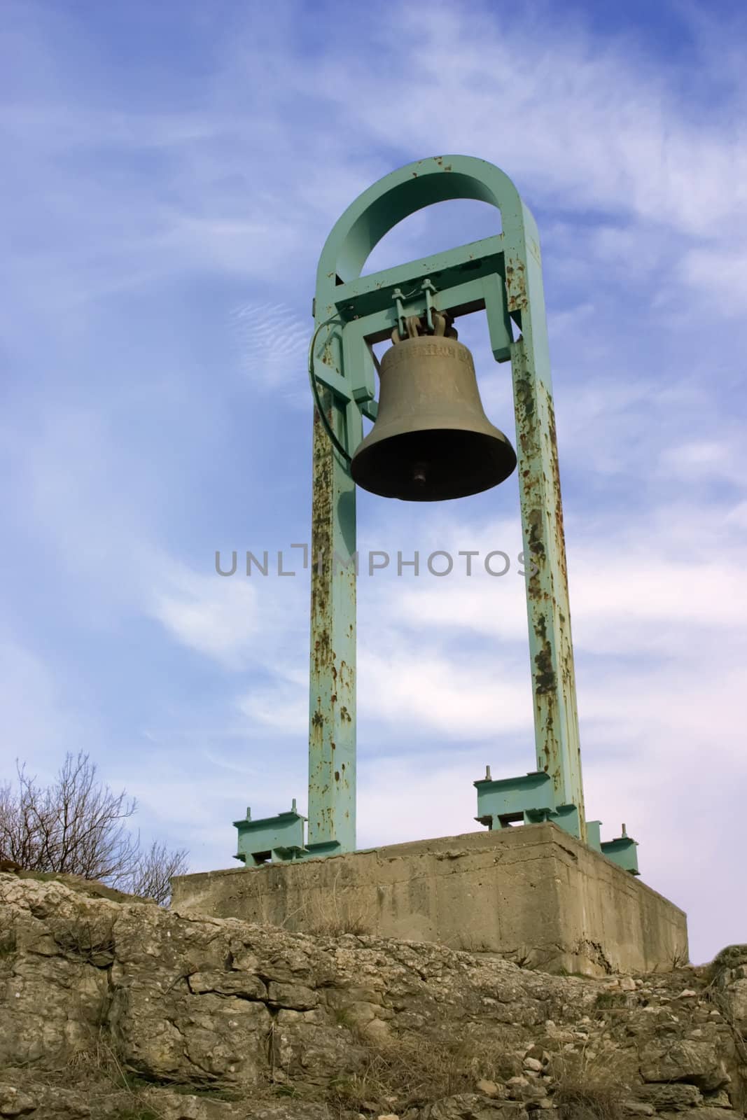 Huge bell in old fortress over blue sky