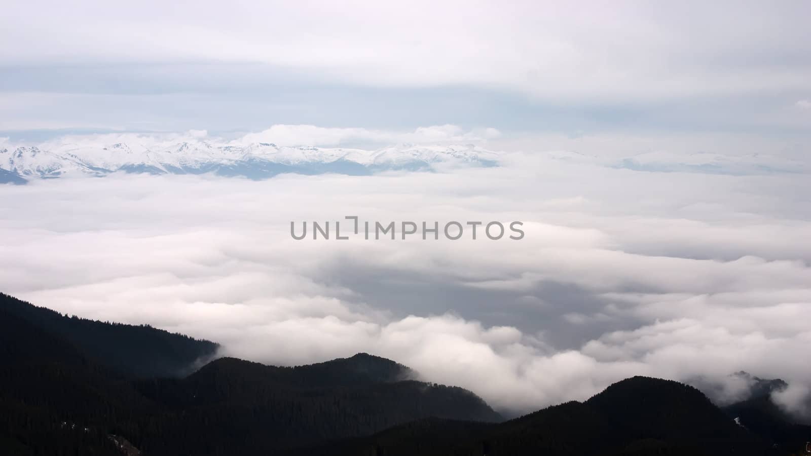 Clouds in mountain valley with hills and trees