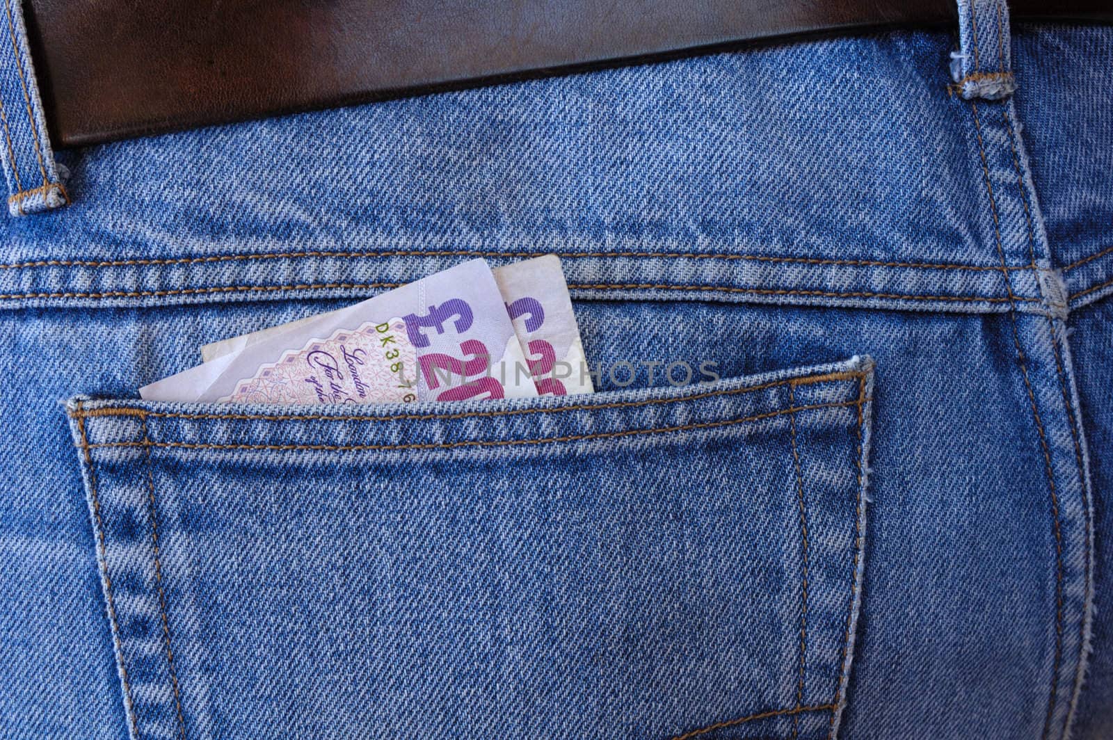 Two 20-pound notes poke out of the rear pocket of someone's jeans. A temptation for a pickpocket.